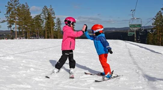 Syskon gör High five i skidbacke, Bjursås.