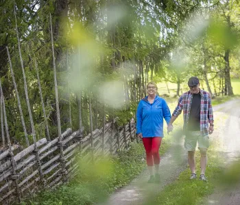 Ett par promenerar hand i hand längs grusväg