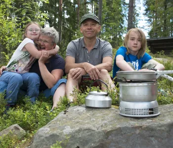 Familj sitter i skogen.