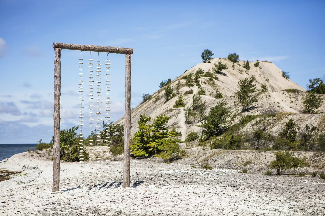 Konstverk av hängande kalkstenar vid havet.