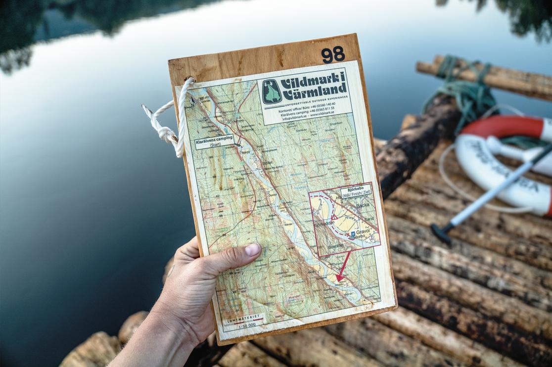 Hand som håller karta med texten Vildmark i Värmland.