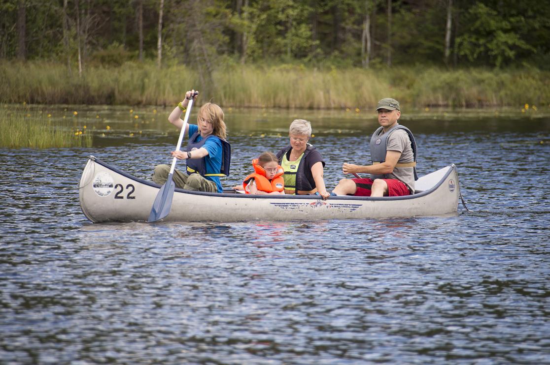 Familj i kanot på sjö.