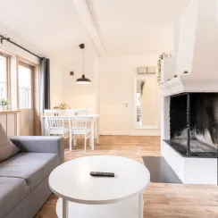 Interiör av stuga på Leksand Resort med soffa, matbord och TV