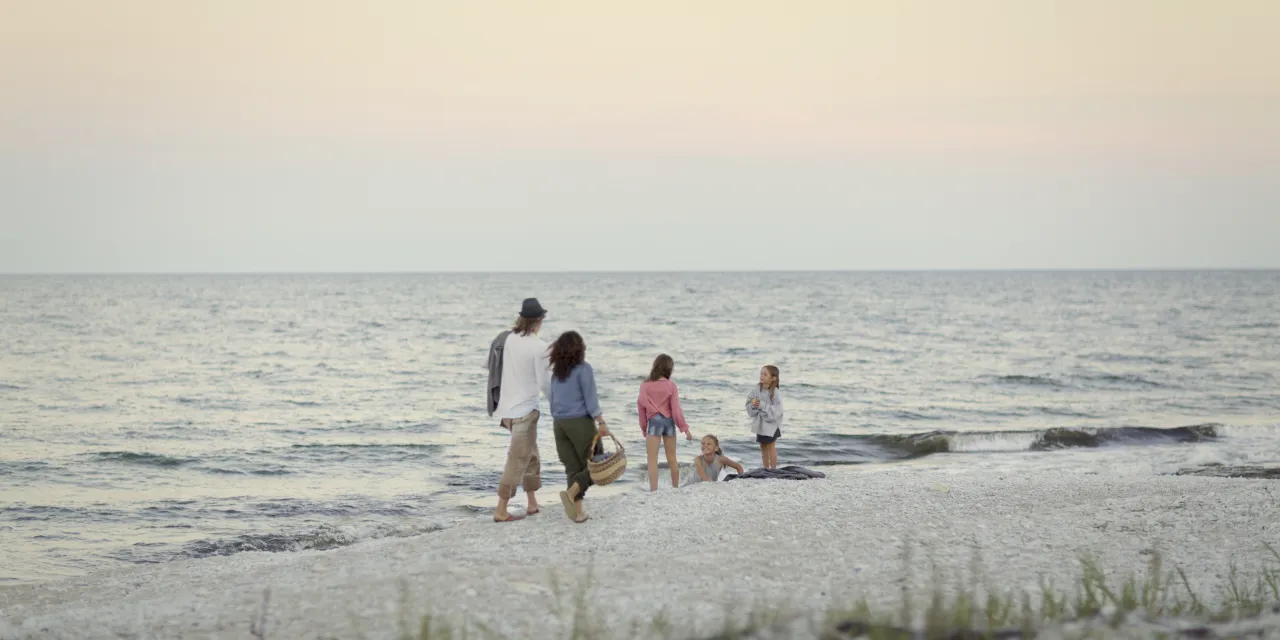 Familj går på strand.